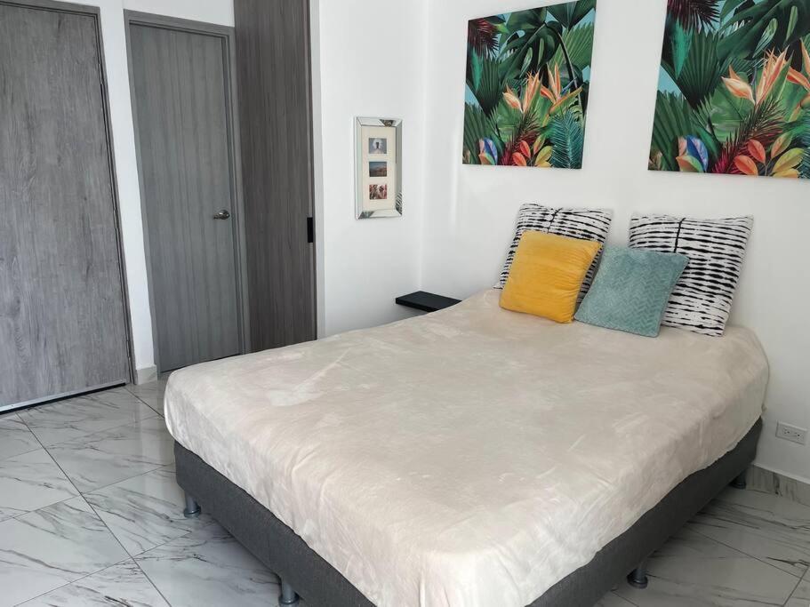 a bedroom with a bed with colorful pillows on it at Studio Panama in Panama City