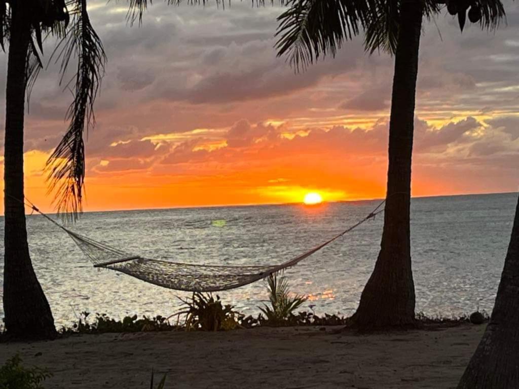 a hammock on a beach with a sunset at Mai Sunset Island Resort in Naviti Island