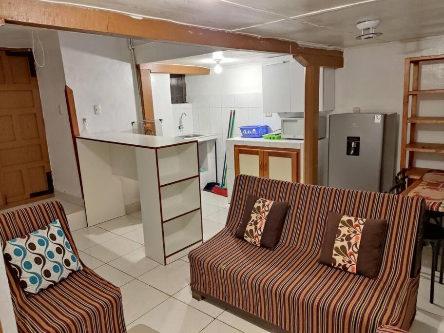 sala de estar con sofá y cocina en Q'osqo Apartments, en Cusco