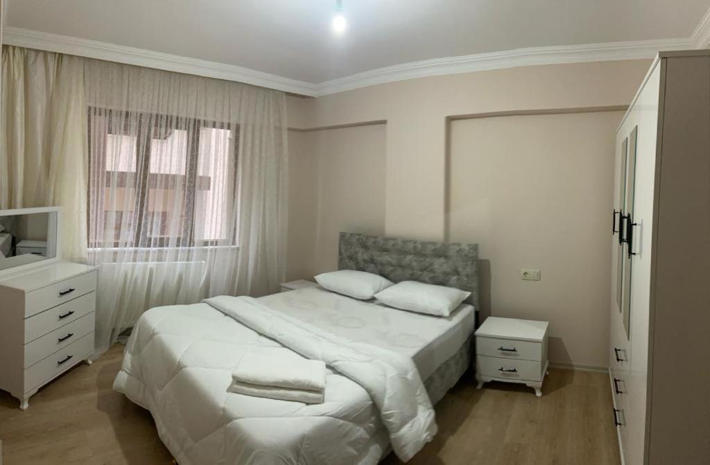 een witte slaapkamer met een groot bed en een raam bij Ecemsuit in Yomra