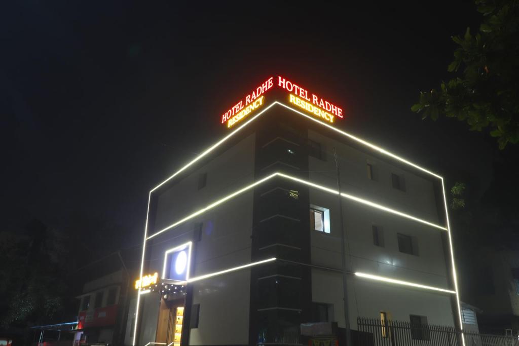 Un bâtiment avec un panneau de néon en haut. dans l'établissement Radhe Residency, à Navi Mumbai