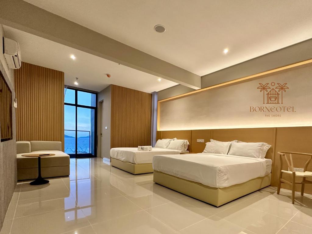 duas camas num quarto de hotel com uma placa na parede em Borneotel The Shore KK by CHG em Kota Kinabalu