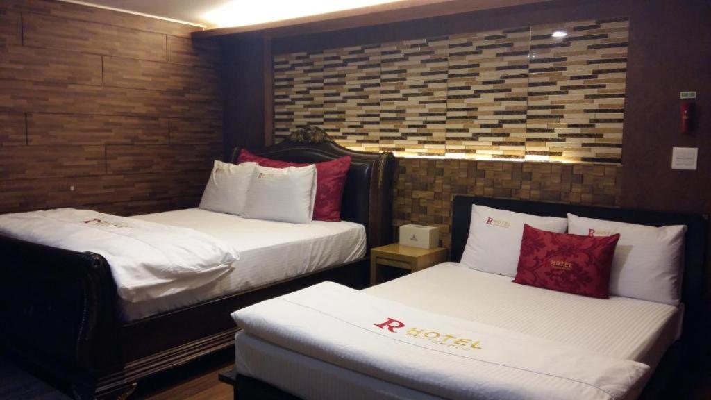 a hotel room with two beds with white and red pillows at Residence R Hotel in Daegu