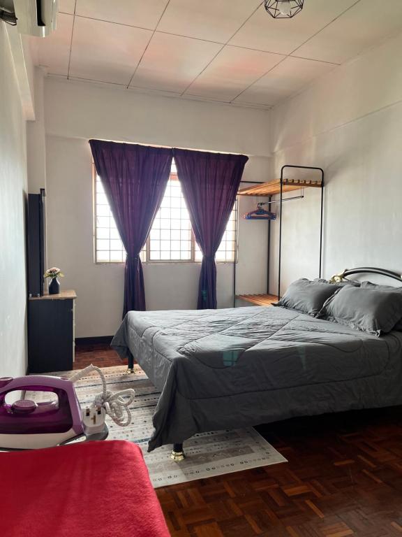 加影的住宿－Homestay Vista3A at Vista Seri Putra，一间卧室配有一张大床和紫色窗帘