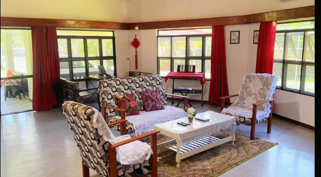 a living room with a couch and two chairs at 机场附近的民宿B in Nadi