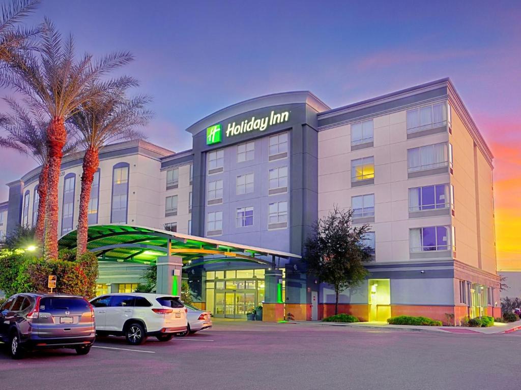 a hotel with cars parked in a parking lot at Holiday Inn Phoenix Airport, an IHG Hotel in Phoenix