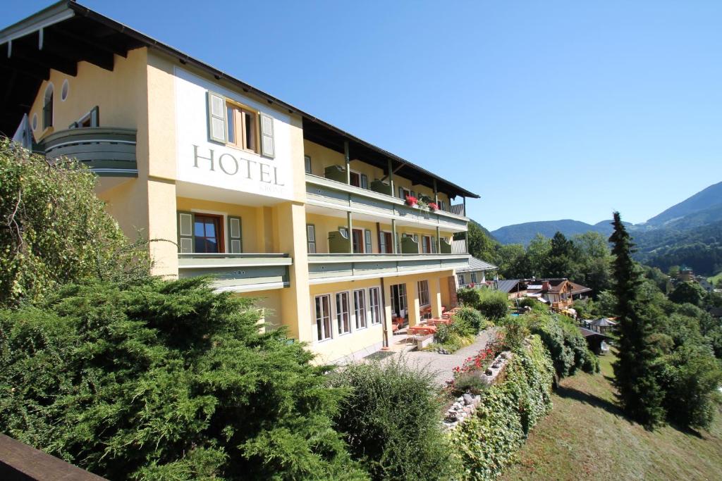 a hotel on the side of a hill with bushes at Hotel Krone in Berchtesgaden