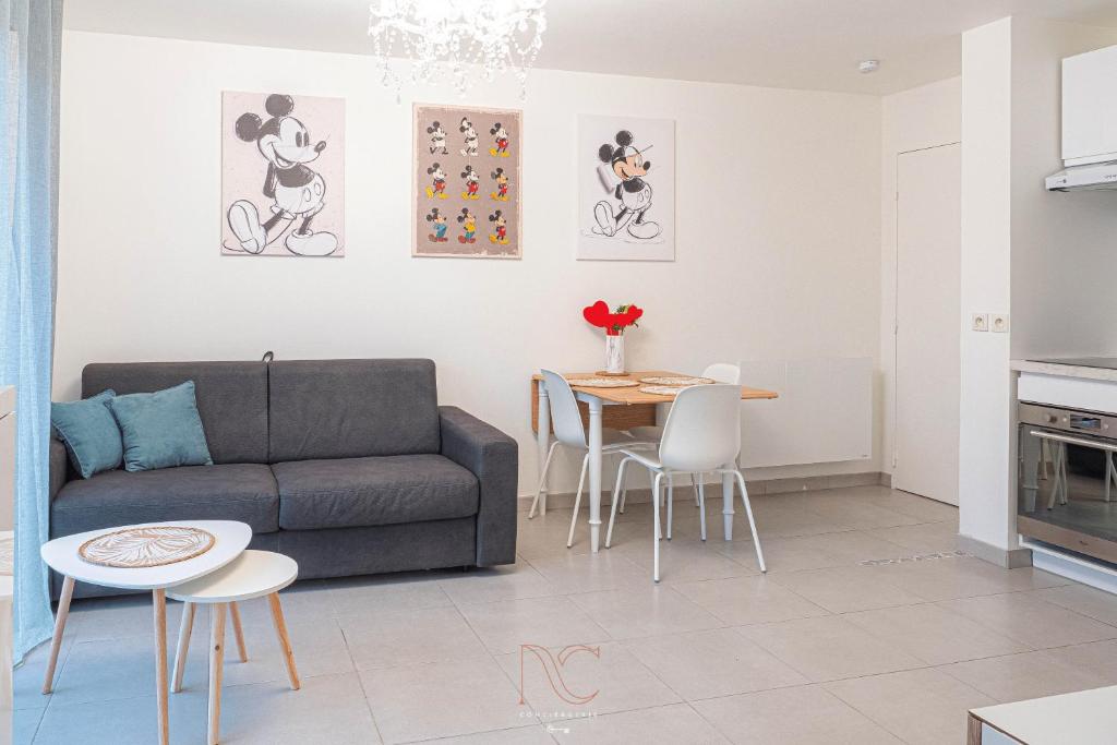 ein Wohnzimmer mit einem Sofa und einem Tisch in der Unterkunft *Disneyland-Paris* 4pers, Parking, Wifi in Chessy