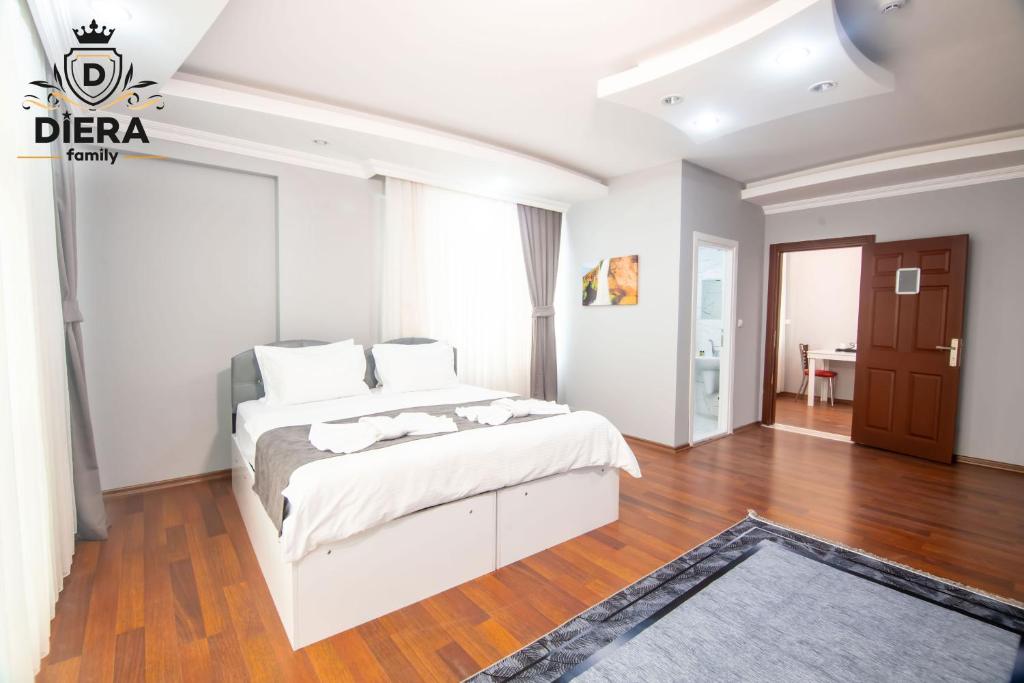 a bedroom with a white bed and a wooden floor at Diera Family Hotel in Atakum