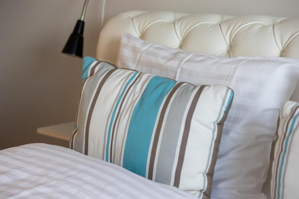 un letto con due cuscini e testata bianca di Hildibrand Apartment Hotel a Neskaupstaður