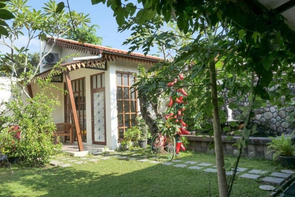 een klein huis met een tuin ervoor bij Veranda Java - Traditional & Modern Javanese Villa in Godean