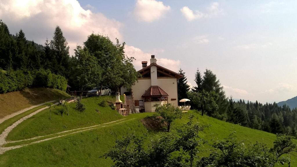 una casa en una colina con un camino que conduce a ella en Baita Agaz, en Sovramonte