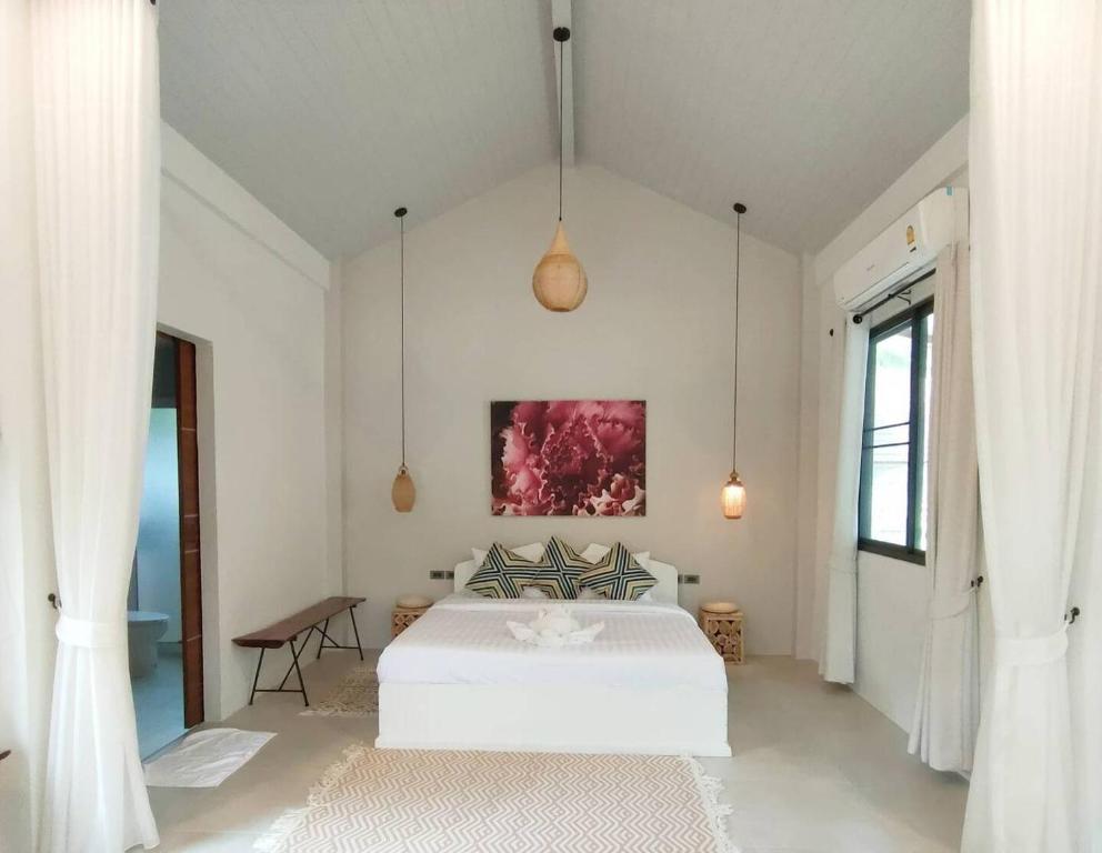 Un dormitorio con una cama blanca y una pintura en la pared en Crystal Bali Style, en Salad Beach