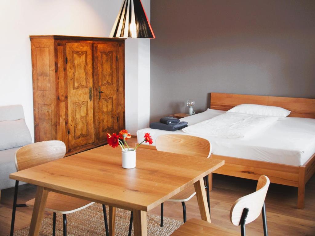 een slaapkamer met een bed en een tafel en stoelen bij Alte Seifensiederei - Thay in Bad Tölz