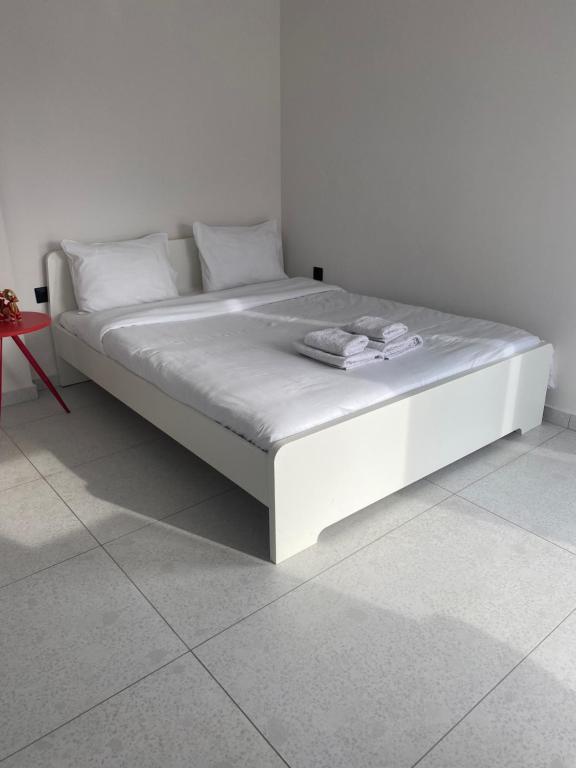 a white bed with two towels on it in a room at Seaview by Agora Flats in Thessaloniki