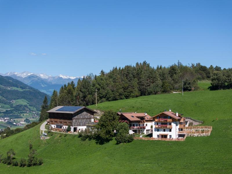a large house on top of a green hill at Proderhof in Laion