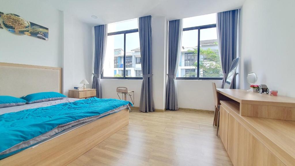 um quarto com uma cama com lençóis azuis e janelas em Hue House Stay em Thôn Trường Giang
