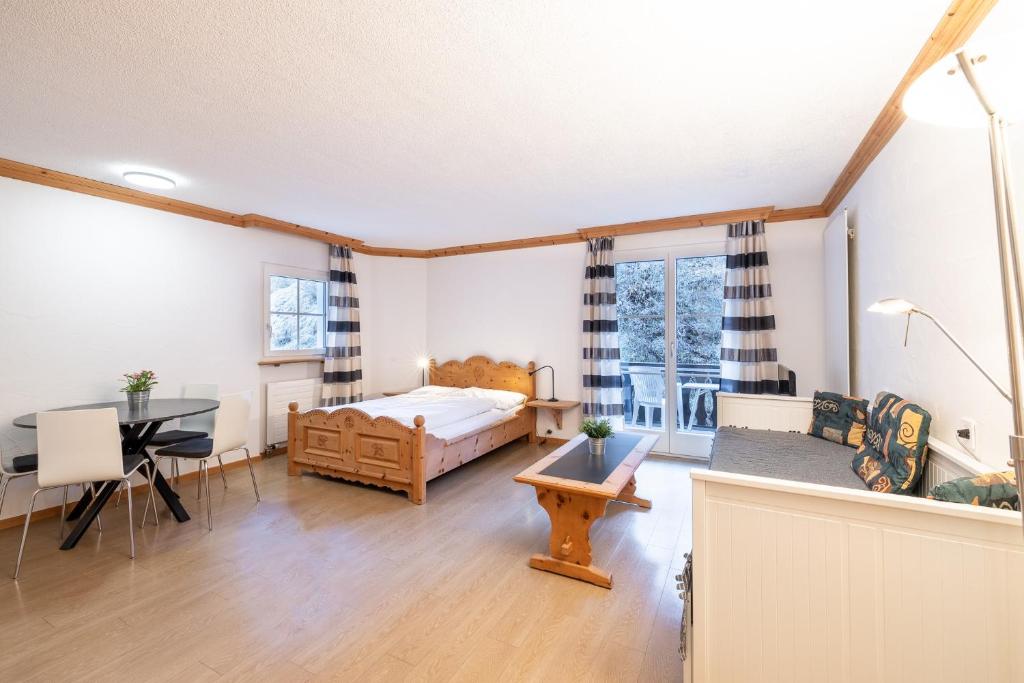 a bedroom with a bed and a desk and a table at 2203 Modernes Studio mit Balkon in Vulpera