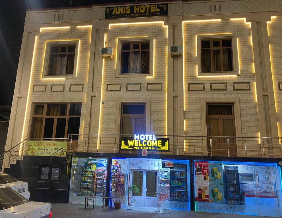 un edificio con un cartel de bienvenida frente al hotel en ANIS HOTEL en Samarcanda