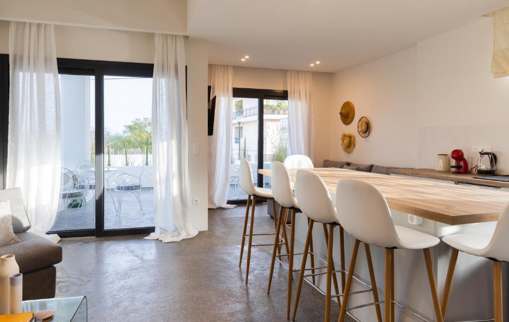 eine Küche mit weißen Stühlen und einem Holztisch in der Unterkunft Luxury Villa in Center of Agioi Theodoroi in Agii Theodori