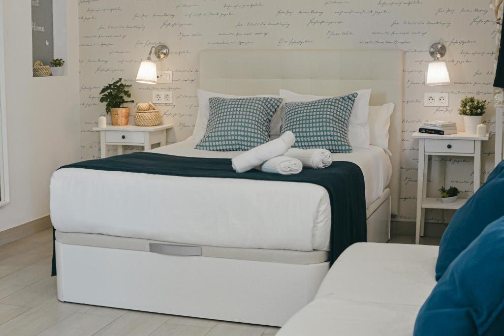 a bedroom with a white bed with two stuffed animals on it at Larios Premium Apartments in Málaga