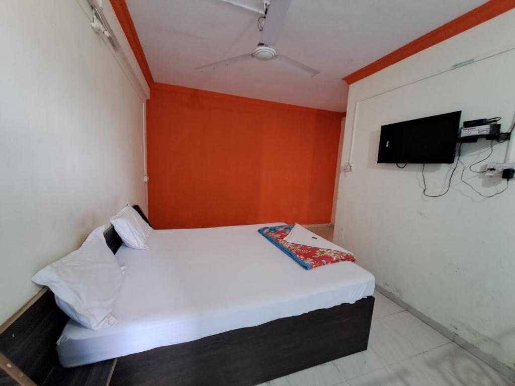 a small room with a bed and a tv at Wonderhills lodge in Hinjewadi