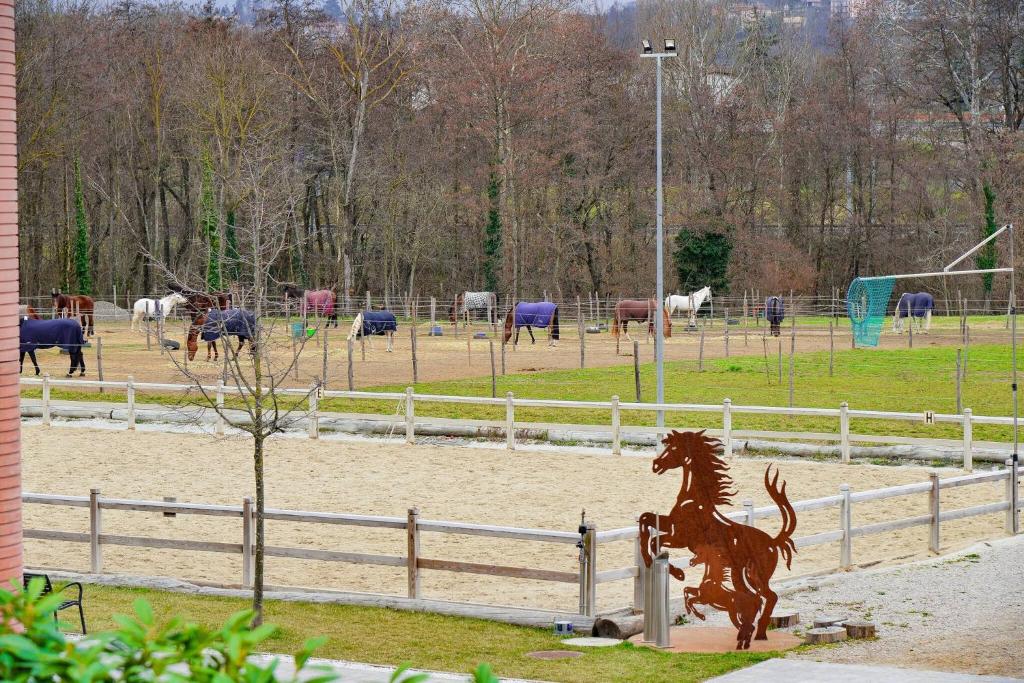 una statua di un cavallo di fronte a un campo di cavalli di Modern apartment Dora a Mendrisio