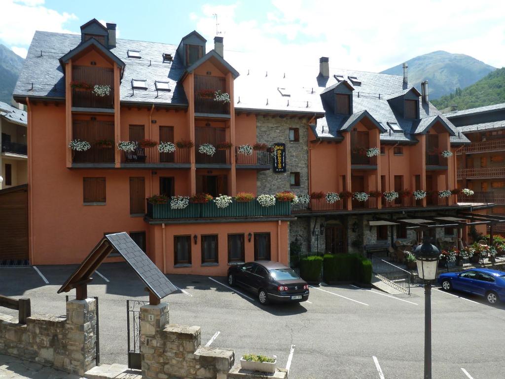 un grand bâtiment avec une voiture garée dans un parking dans l'établissement Hotel Sabocos, à Panticosa