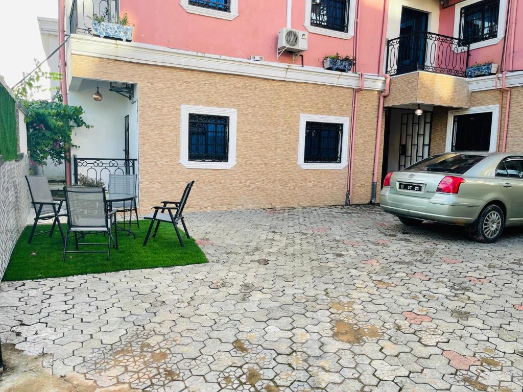 ein Auto, das vor einem Gebäude mit einem Tisch und Stühlen geparkt ist in der Unterkunft Residence SVET in Kribi