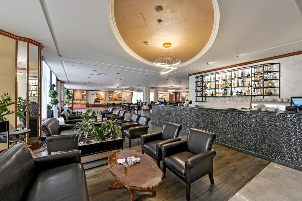 a restaurant with leather chairs and a bar at A Hoteli - Hotel Izvor in Arandelovac