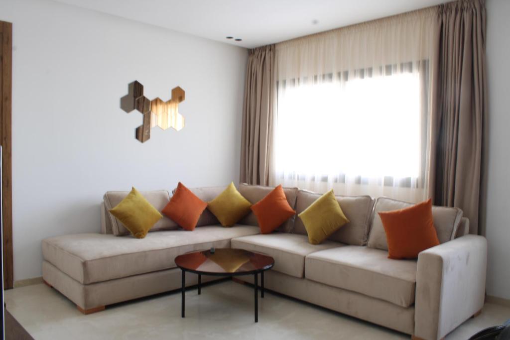 - un salon doté d'un canapé avec des oreillers orange et jaune dans l'établissement Sublime studio en plein centre, à Casablanca
