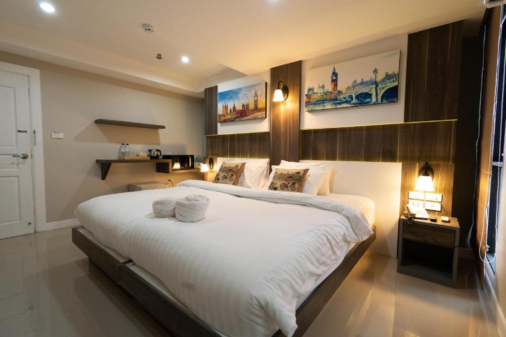 a bedroom with a large bed with white sheets at We Resident Hotel in Hat Yai