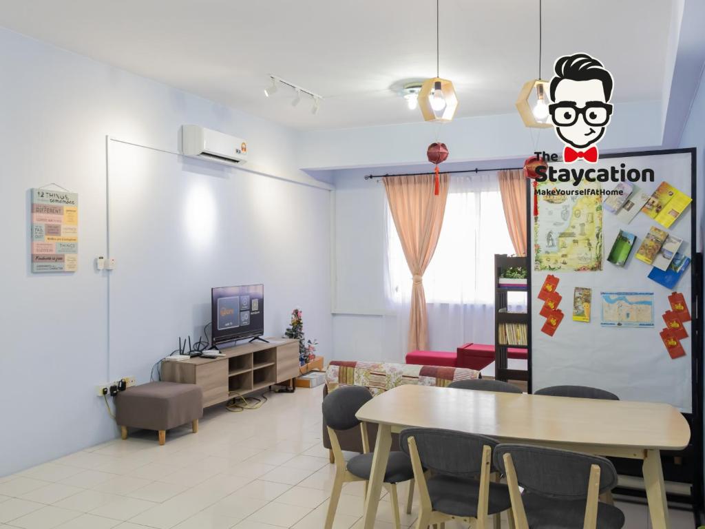Pokój ze stołem i krzesłami oraz telewizorem w obiekcie Staycation Homestay 33 Floridale Condominium near viva city w mieście Kuching