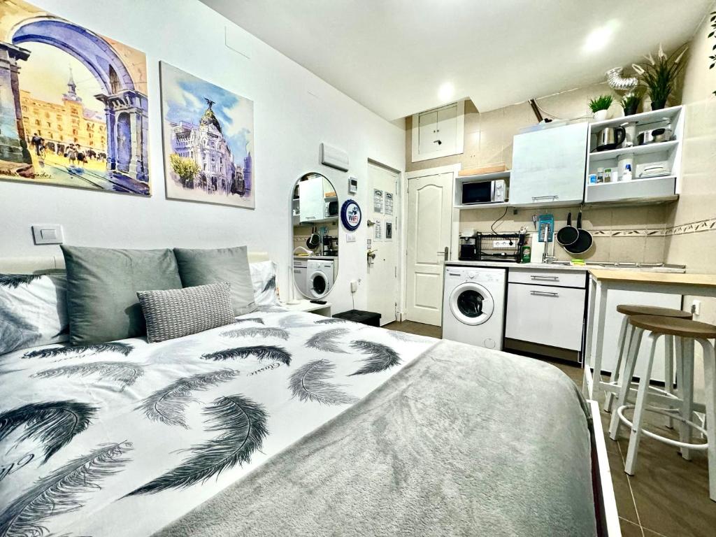 a bedroom with a large bed and a kitchen at Acogedor apartamento en el Centro de Madrid in Madrid