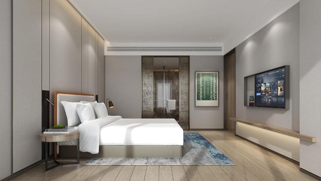 1 dormitorio con cama blanca y baño en Holiday Inn Express Mianyang Sci-Tech City, an IHG Hotel en Mianyang