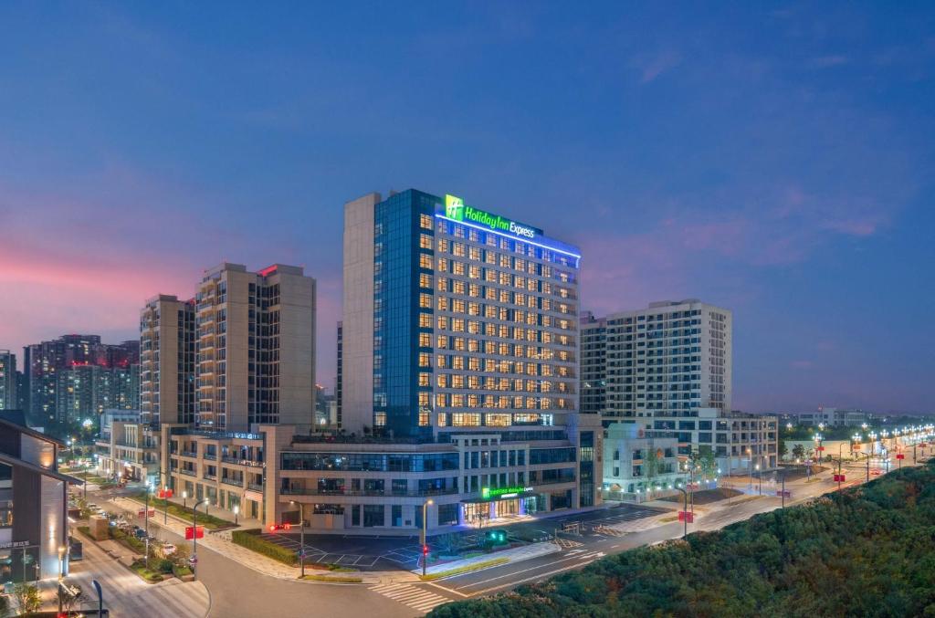 un edificio iluminado en una ciudad por la noche en Holiday Inn Express Mianyang Sci-Tech City, an IHG Hotel, en Mianyang