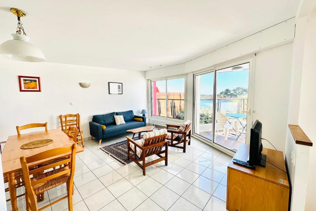 un salon avec un canapé bleu et une table dans l'établissement Charmante maison les pieds dans l'eau, à Ploemeur