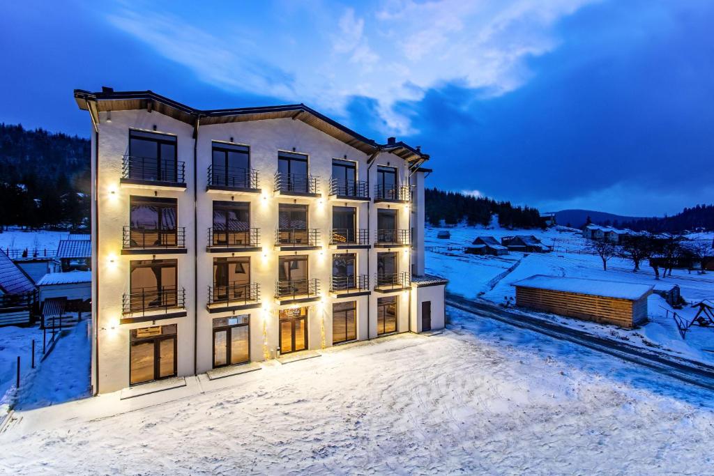 a building with lights on it in the snow at GARDA - Breakfast included in the price Restaurant Free Parking Mountain view Kitchen in the apartment separate entrance in Bukovel