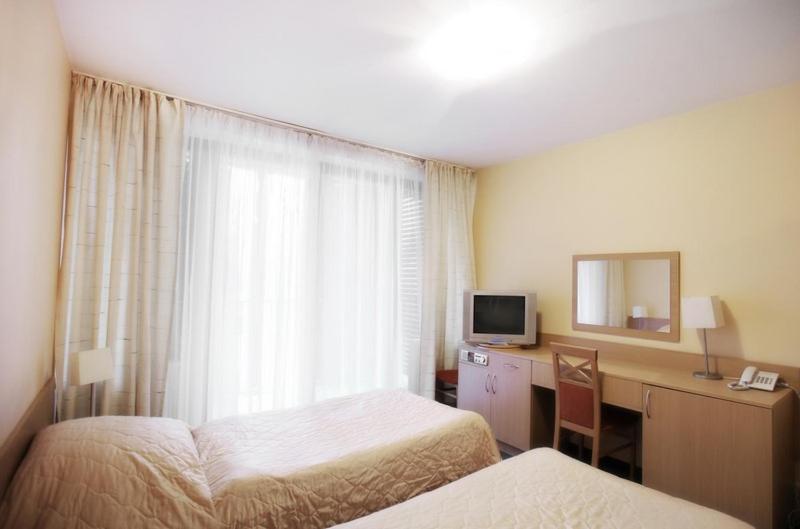 a hotel room with two beds and a desk with a mirror at Jesienna Rezydencja in Nałęczów