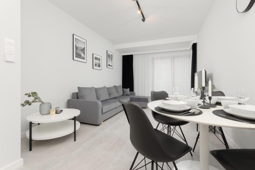 a white living room with a table and chairs at Apartment with Balcony by the Park in Łódź by Renters Prestige in Łódź