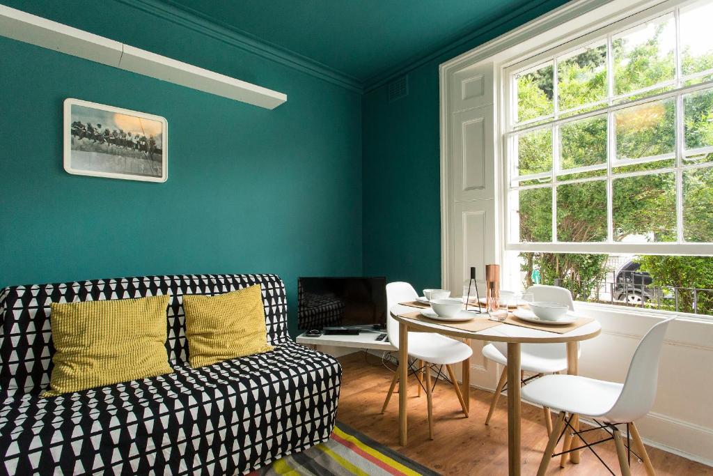 a living room with a couch and a table at Camden Apartment By Morethanstays in London