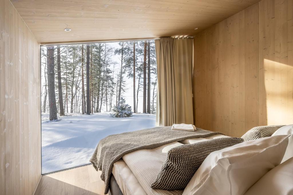 a bedroom with a bed and a large window at Kanava Resort in Savonlinna
