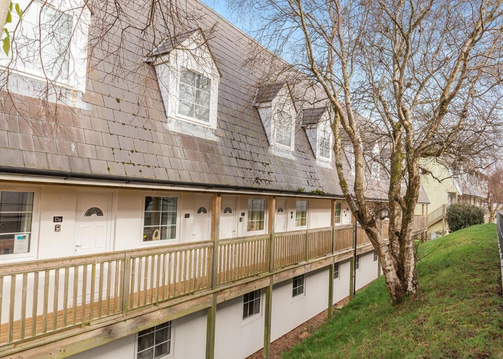 una casa con una valla de madera y un árbol en North Devon Resort, en Ilfracombe