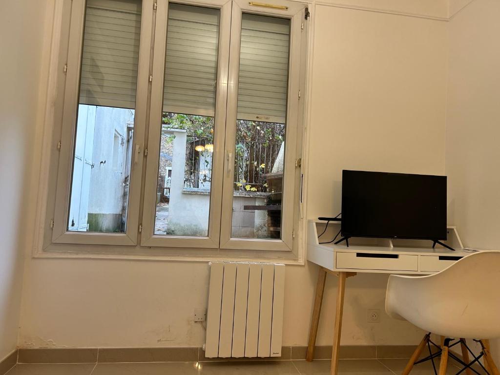 Televízia a/alebo spoločenská miestnosť v ubytovaní Grand logement Centre Ville Massy