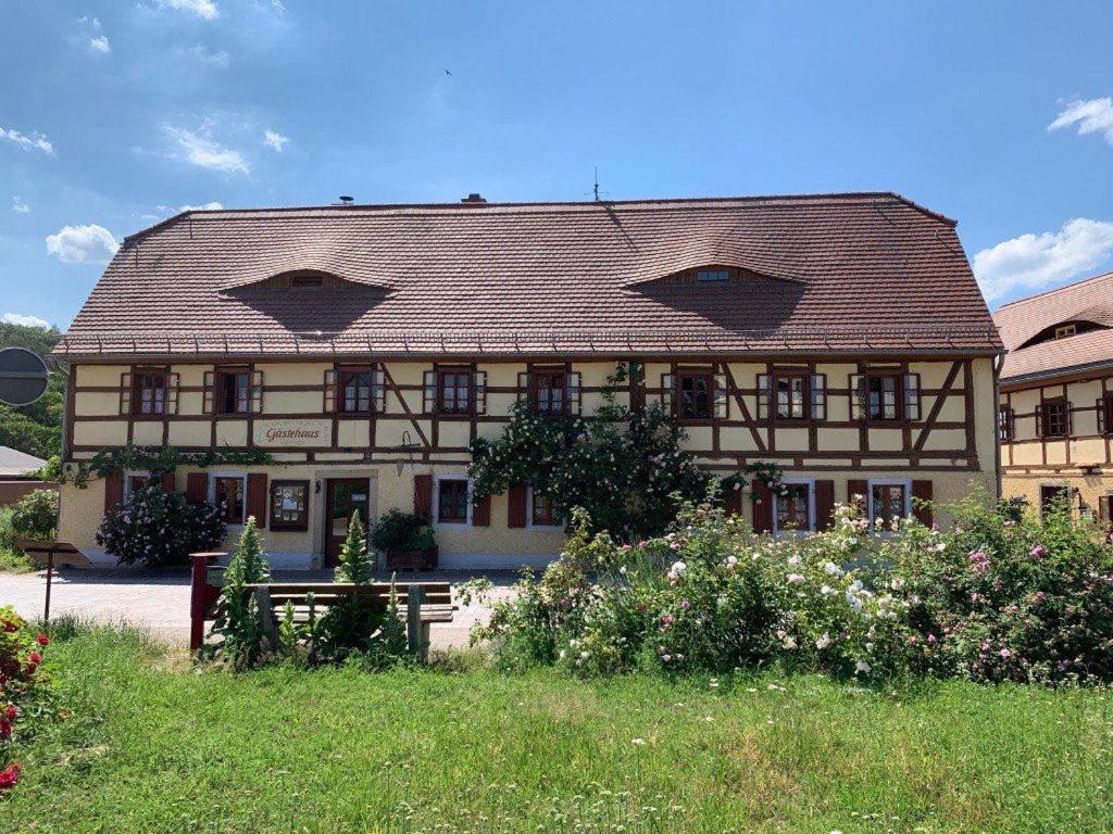 un gran edificio con un banco delante en Fachwerkhof Klosterbuch, en Leisnig