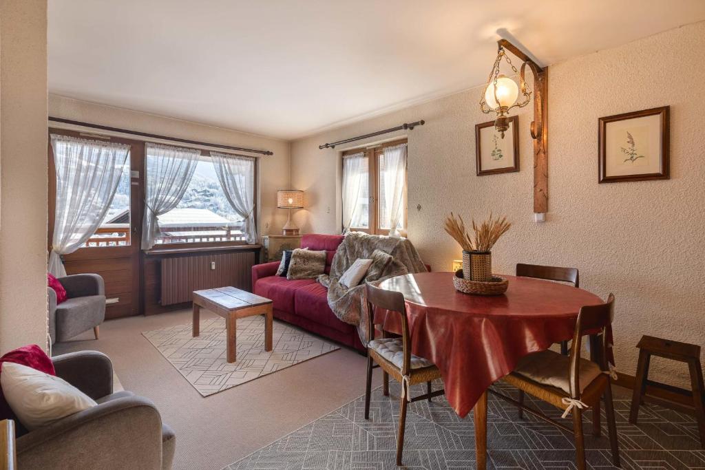 uma sala de estar com um sofá vermelho e uma mesa em Flat Synerveda em Megève