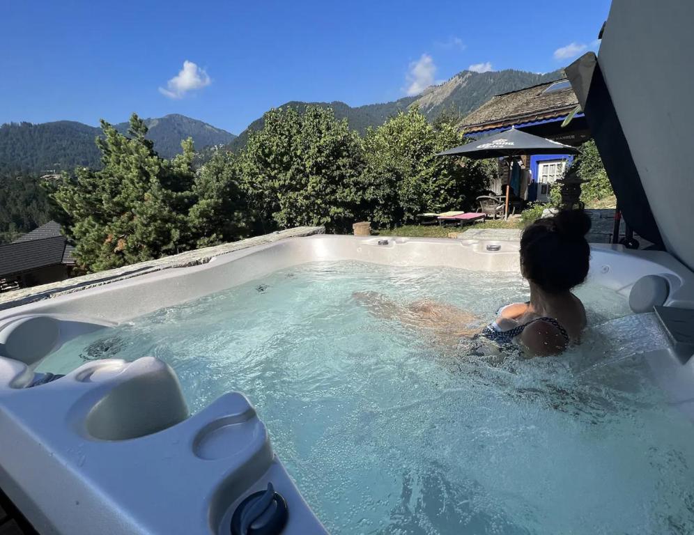 a young girl is sitting in a jacuzzi tub at Le Petit Nid d'Amour, Propriétés Mont Amour in Montriond