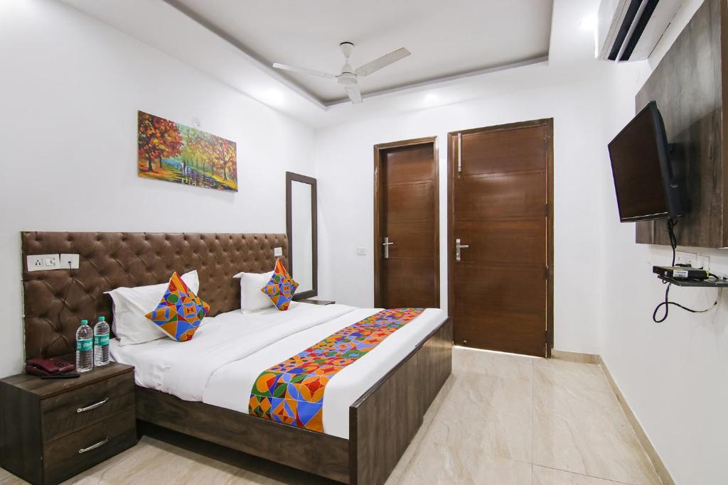 um quarto com uma cama e uma televisão de ecrã plano em FabExpress The Premium Villa em Nova Deli