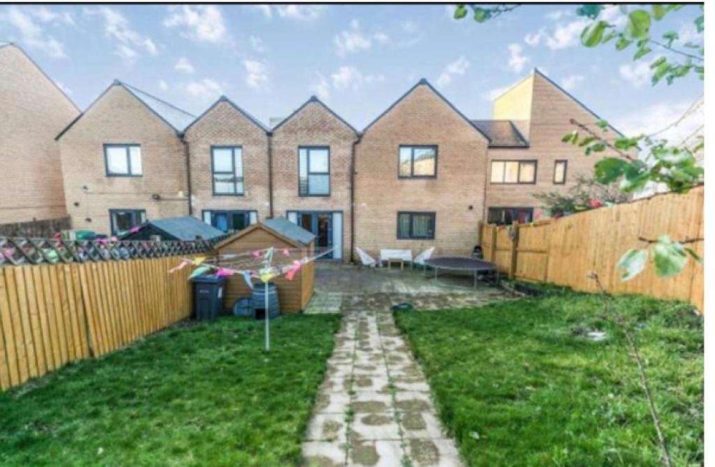 a large brick house with a fence in a yard at Birmingham Guesthouse in Birmingham