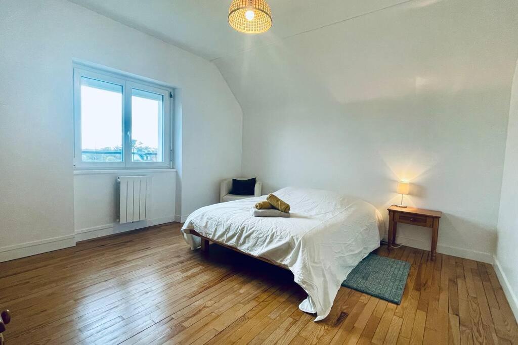 ein weißes Schlafzimmer mit einem Bett und einem Fenster in der Unterkunft TI Huel in Camaret-sur-Mer